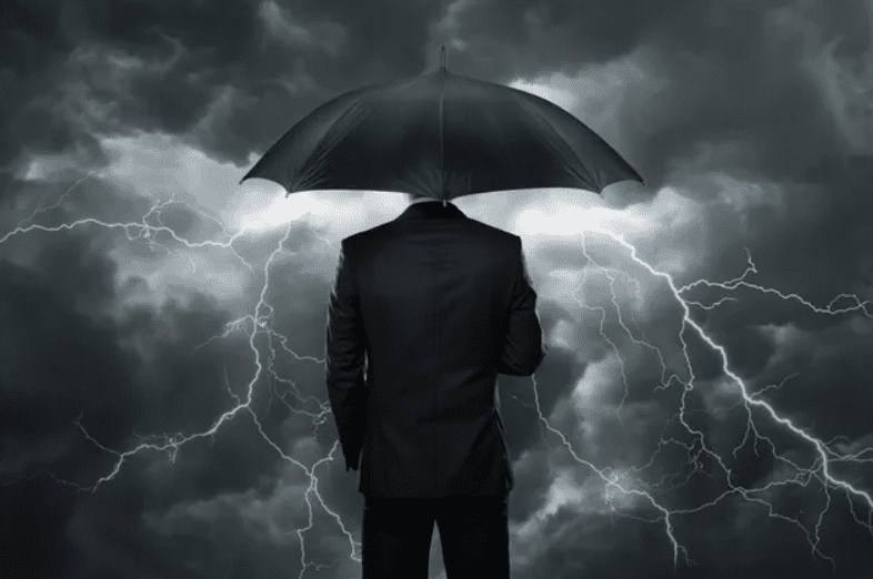 Silhouetted businessman with umbrella standing in dramatic lightning storm