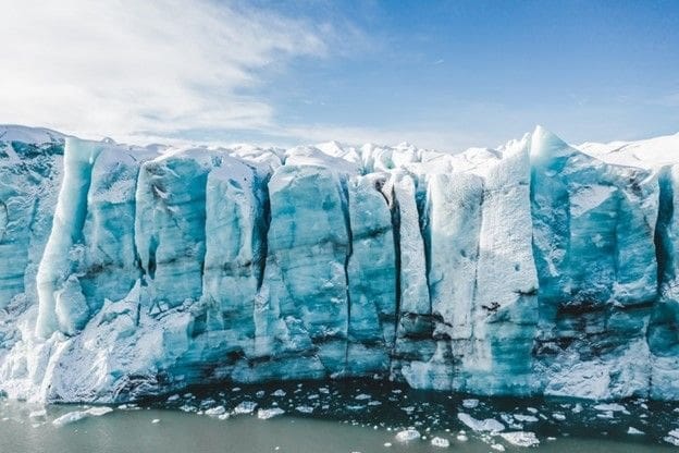 Turquoise glacier with towering ice formations and snow